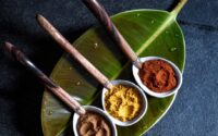 a plate with three bowls of spices on it
